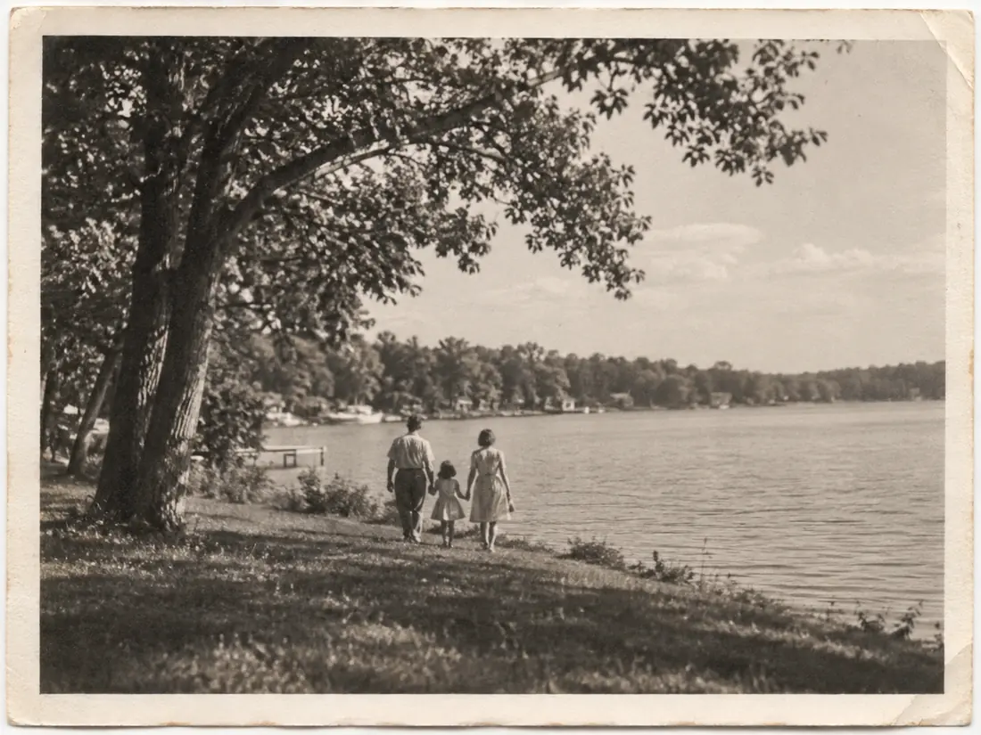 Illustrative archival photograph of a family walking beside a lake